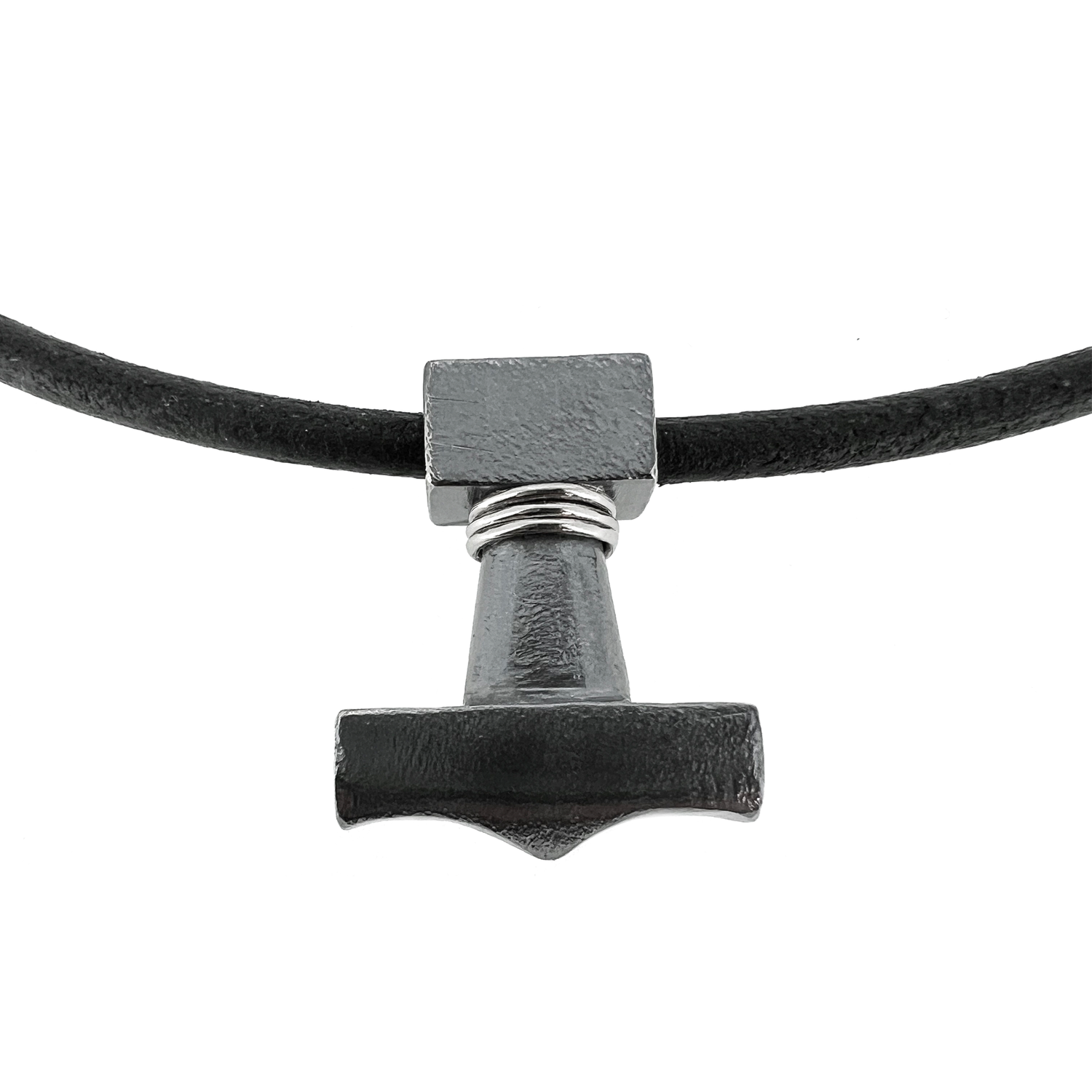 Svart Þórshamars hálsmen - oxiderað títaníum með 4mm svartri fléttaðri leðursnúru með títaníum segullási. Þórshamarinn er flottur skartgripur, tákn úr norrænni goðafræði úr oxideruðu títaníum. Veldu leðurlengd og berðu með þér kraftinn af ógnvekjandi vopni Þórs, sem getur jafnað fjöll, hvert sem þú ferð.