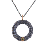 HRAUN - Títaníum hálsmen með peridot steini, býður upp á fullkomna blöndu af styrk og glæsileika með 9k rósagullhálsmen 1x1,5mm peridot stein. Hugmyndin af hönnun hálsmenssins er fengin frá íslenska hrauninu.  Áferðin handgrafin í títaníummenið og þar næst er það oxiderað og pólerað til á ná þessu einstöka útliti.  Menið kemur með 1,9mm þykkri títaníumkeðju og humarlási, sem veitir meninu endingu og öryggi. Ófeigur gullsmiðja - ofeigur.is