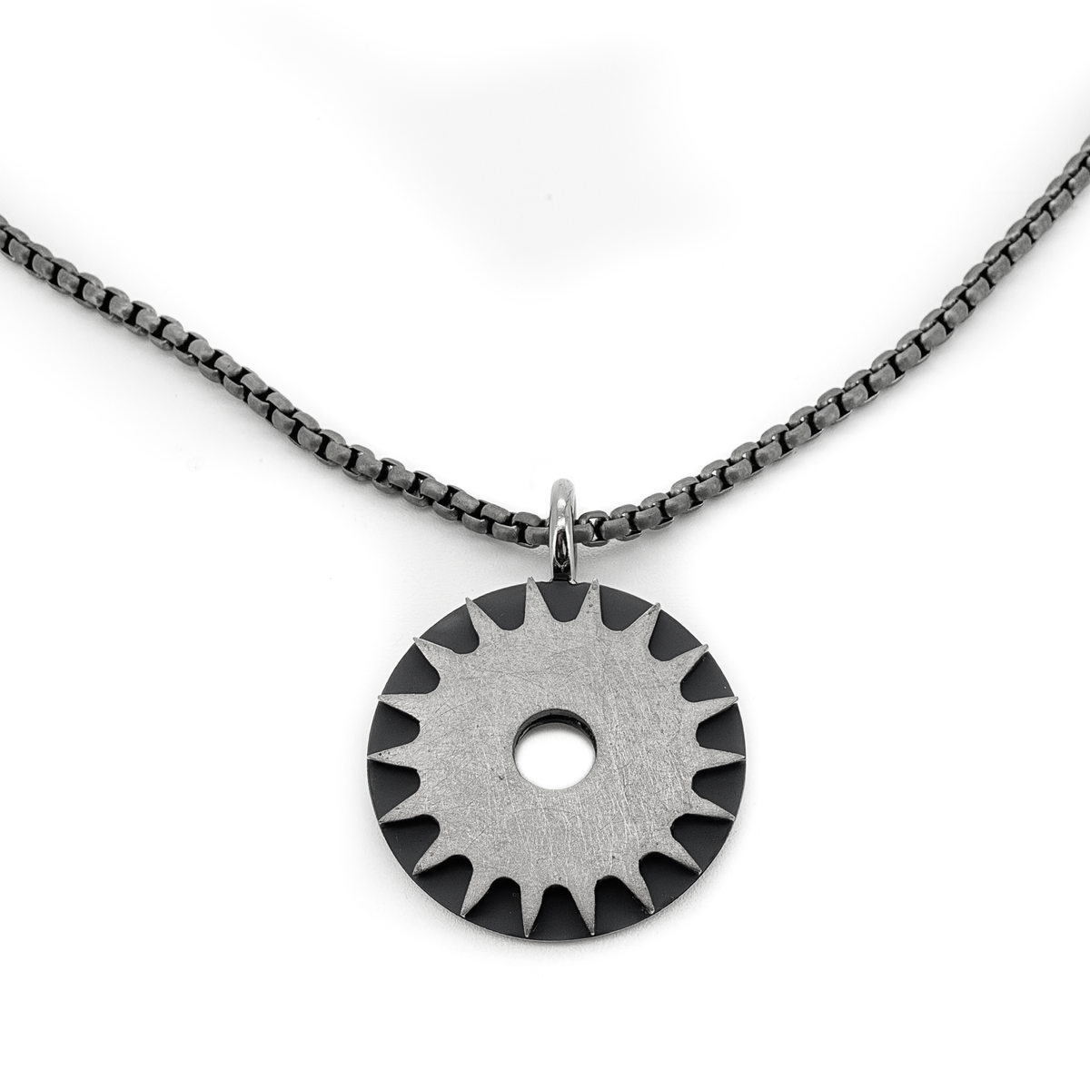 Solar Power is a bold titanium pendant by Zeezen, designed by Bolli Ófeigsson. Its oxidized finish and rugged surface give it a raw, distinctive character.