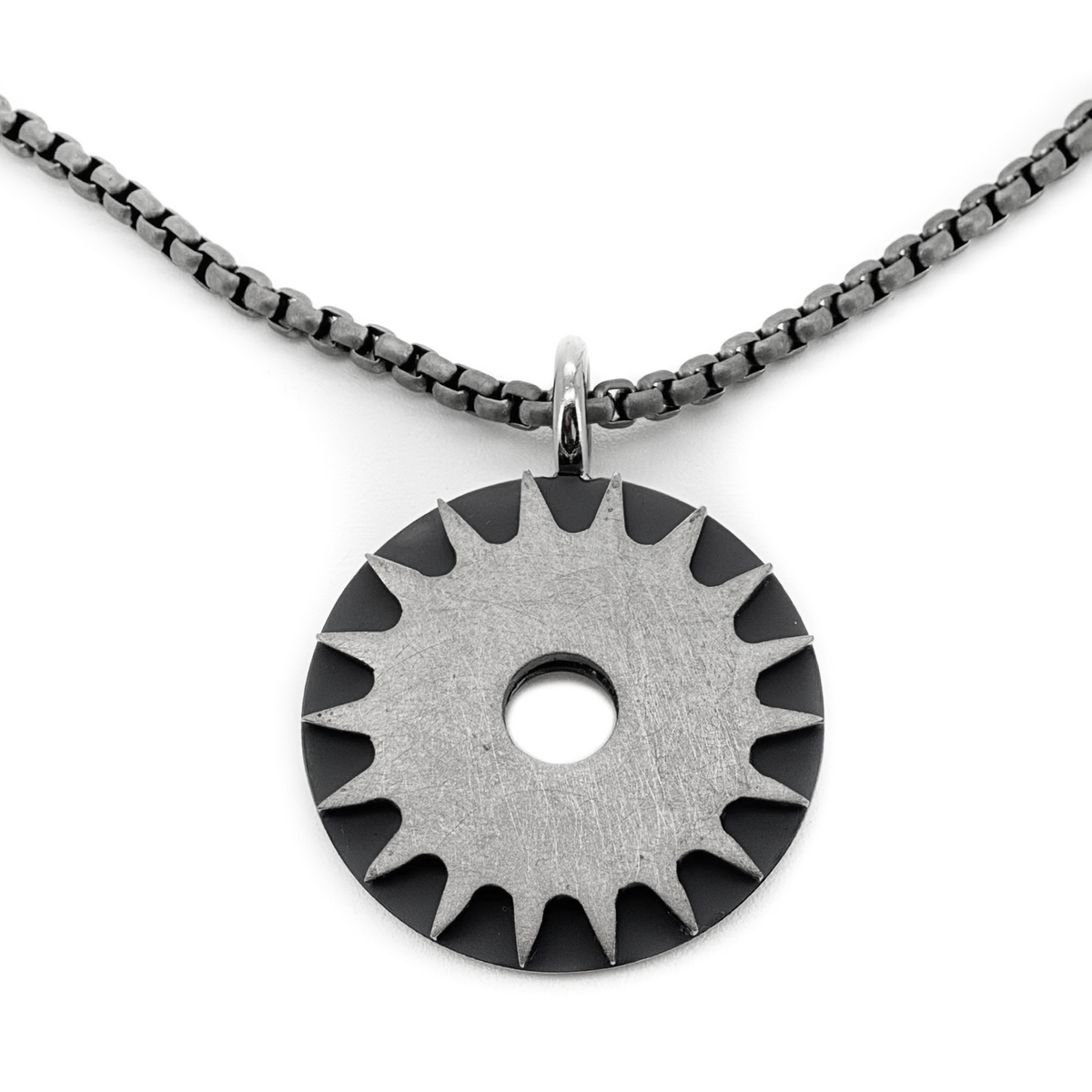 Solar Power is a bold titanium pendant by Zeezen, designed by Bolli Ófeigsson. Its oxidized finish and rugged surface give it a raw, distinctive character.